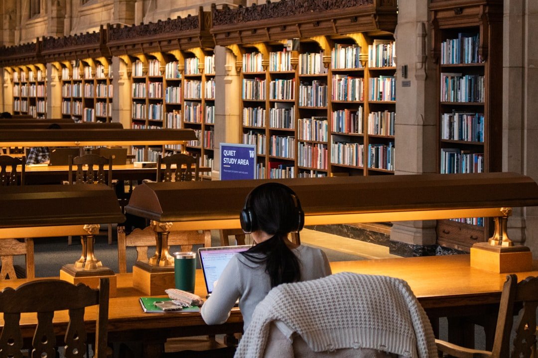 Student studying with a laptop in a library, representing an AI homework-helper app