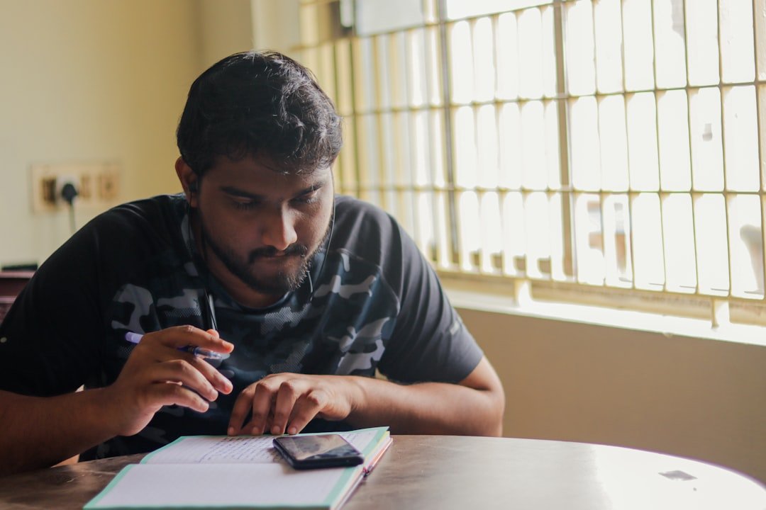 Person writing notes at a desk, representing studying and homework help