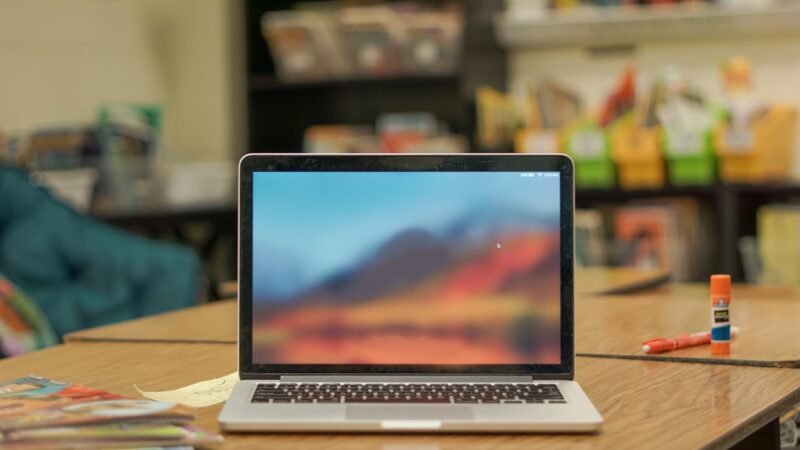 Laptop on a desk in a school classroom representing an AI teaching assistant tool