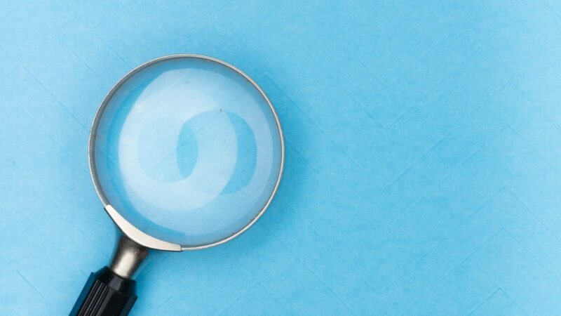 Magnifying glass resting on a table representing search engine queries