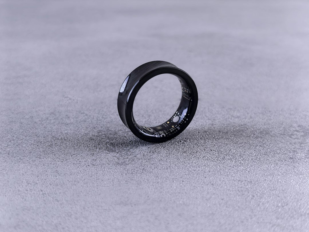 A black smart ring resting on a gray surface, the wearable category driving Oura's public offering