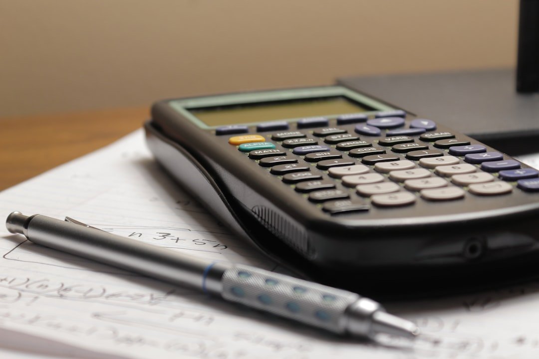 Calculator and pen resting on a notebook page, representing homework help