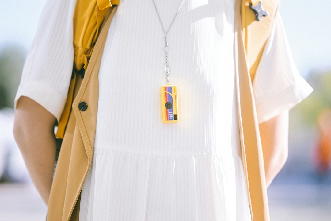 Person wearing a small clip-on wearable device around their neck
