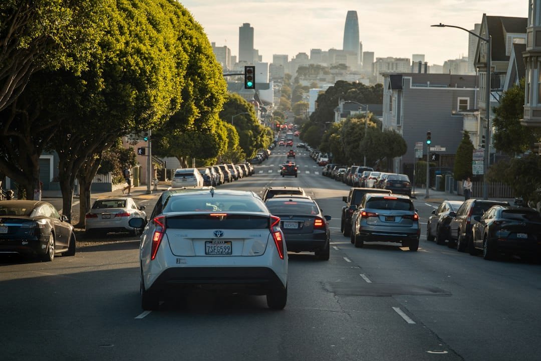 Cars driving down a downtown city street toward the skyline, representing ride-hailing traffic