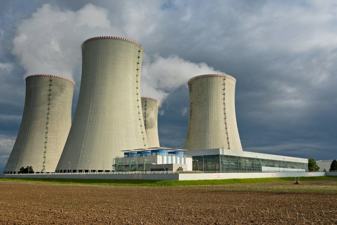 Four concrete cooling towers emitting steam, illustrating nuclear reactor infrastructure being built for Google's data centers