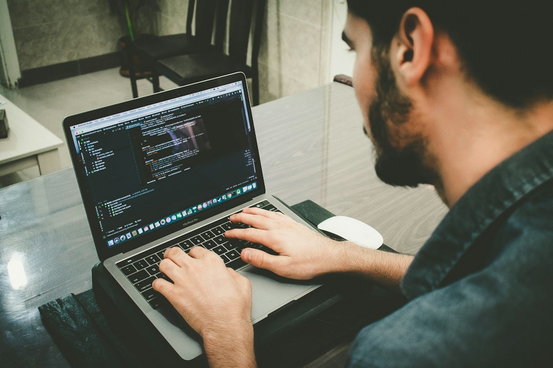 Developer typing code on a laptop, representing AI coding assistants