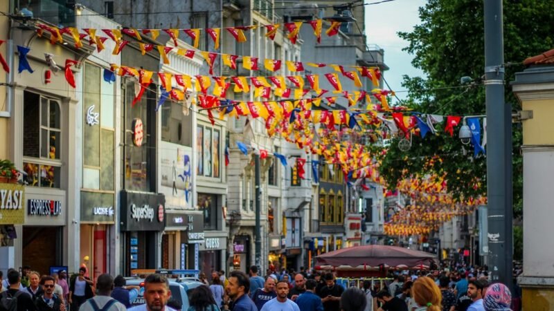 Crowded European street lined with shops and festive flags