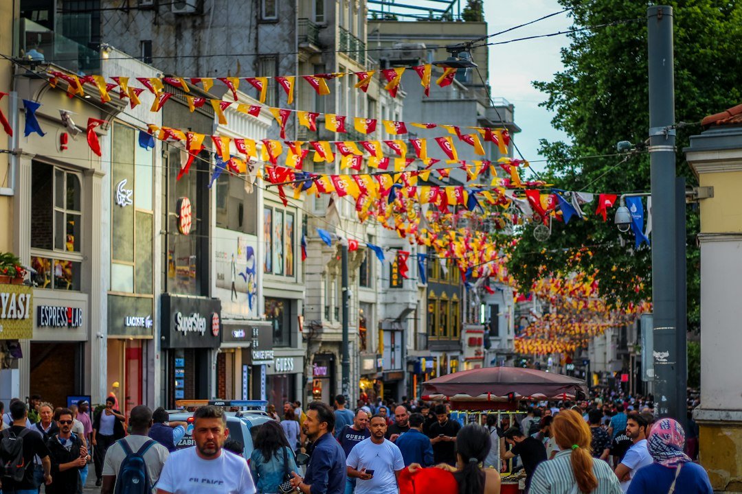 Crowded European street lined with shops and festive flags