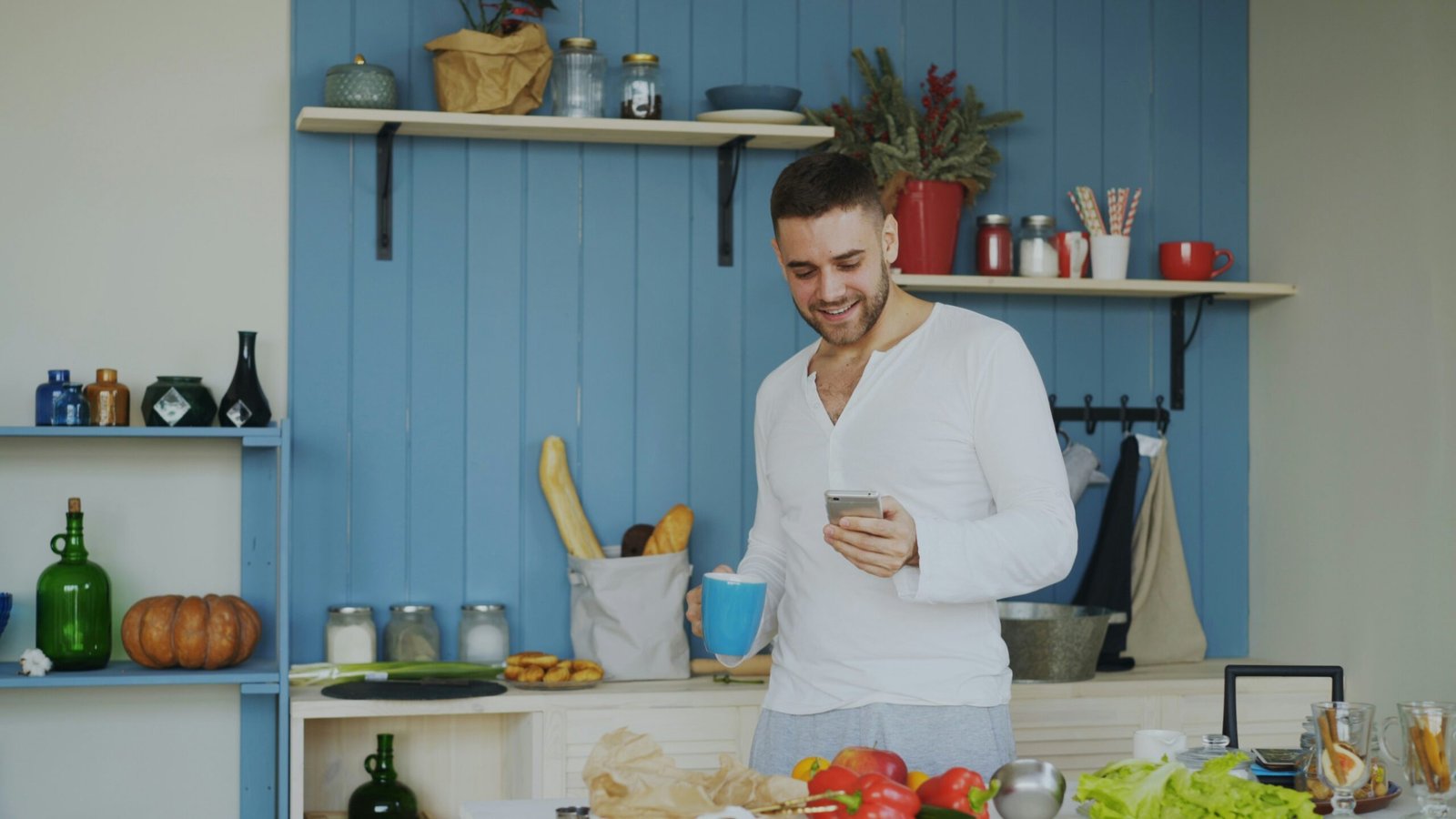 Person in a kitchen using a smartphone while doing an everyday task, the kind of footage startups now pay for