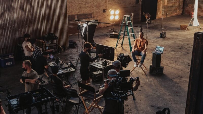 Film crew standing around a camera setup on a production set, representing the merged Paramount and Warner Bros. studios