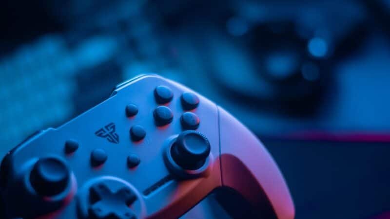 Close-up of a video game controller lit with blue ambient light