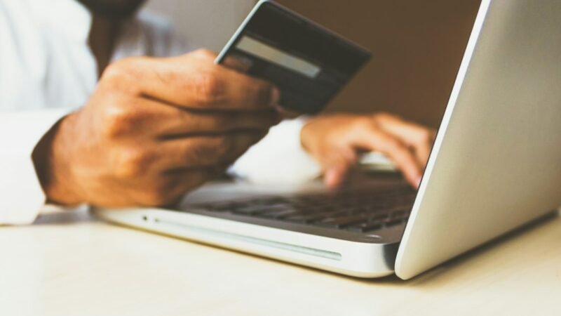 Person holding a credit card while completing an online checkout