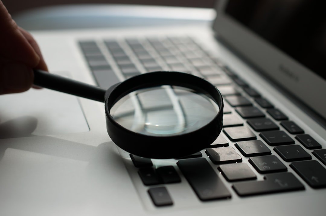 Magnifying glass over a search page on a laptop, representing changes to Google Search and AI Mode