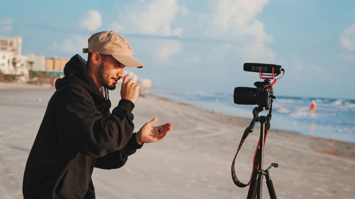 Content creator holding a camera, representing creators now eligible for Google Search profiles