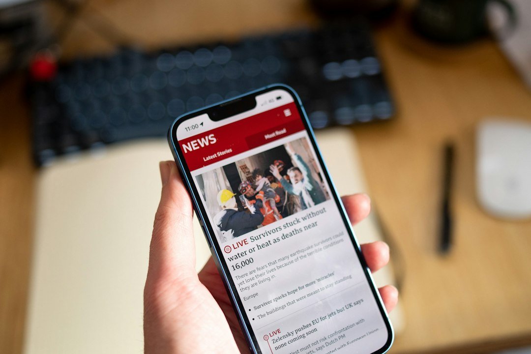 A hand holding a phone while browsing current events news stories, illustrating Google Discover's new AI summary feature