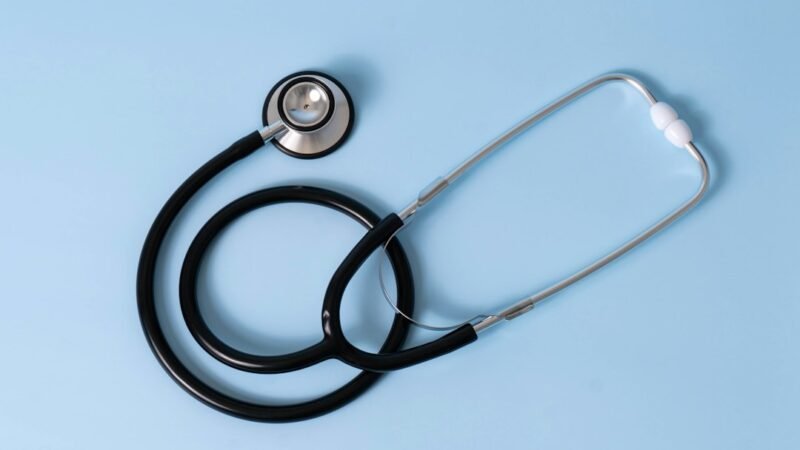 Medical billing paperwork and a stethoscope on a desk, representing AI-driven healthcare coding costs