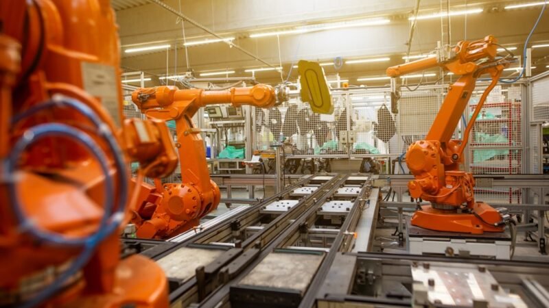 Industrial robotic arms assembling products on a factory line