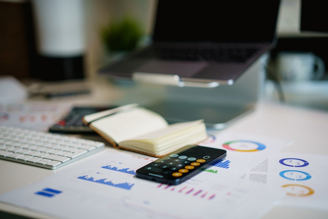 Laptop displaying financial data charts and graphs on a desk