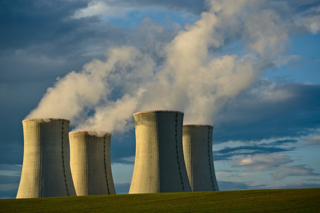 Nuclear power plant cooling towers under a blue sky, representing new nuclear investment for data centers