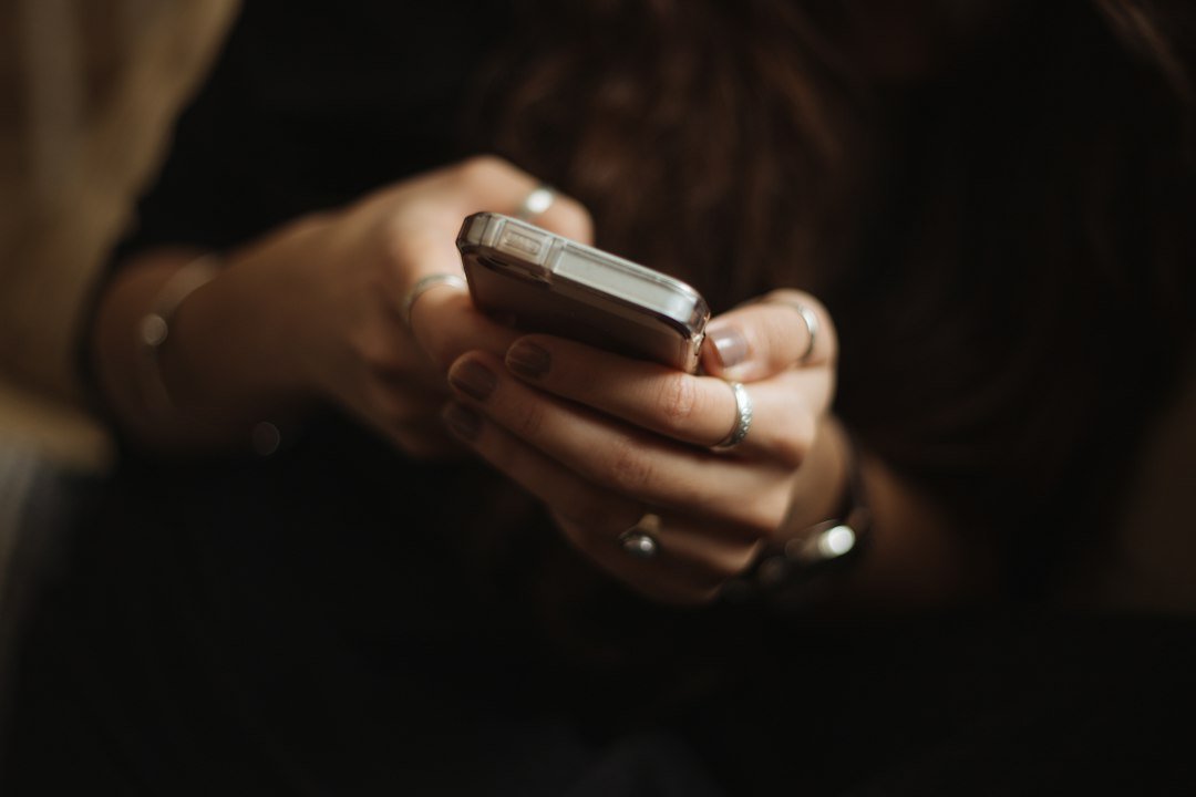 Person browsing content on a smartphone, representing publisher traffic at stake as Google tests Discover's new AI overview feature