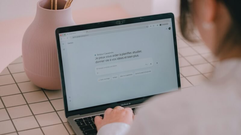 Person typing a prompt into an AI chatbot on a laptop
