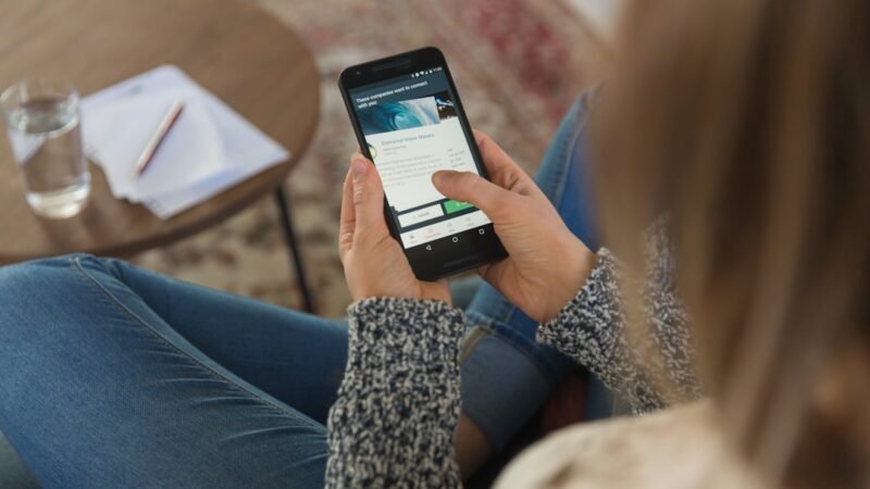 Person holding a smartphone with an AI assistant app open, illustrating the mobile AI app race between Meta and OpenAI