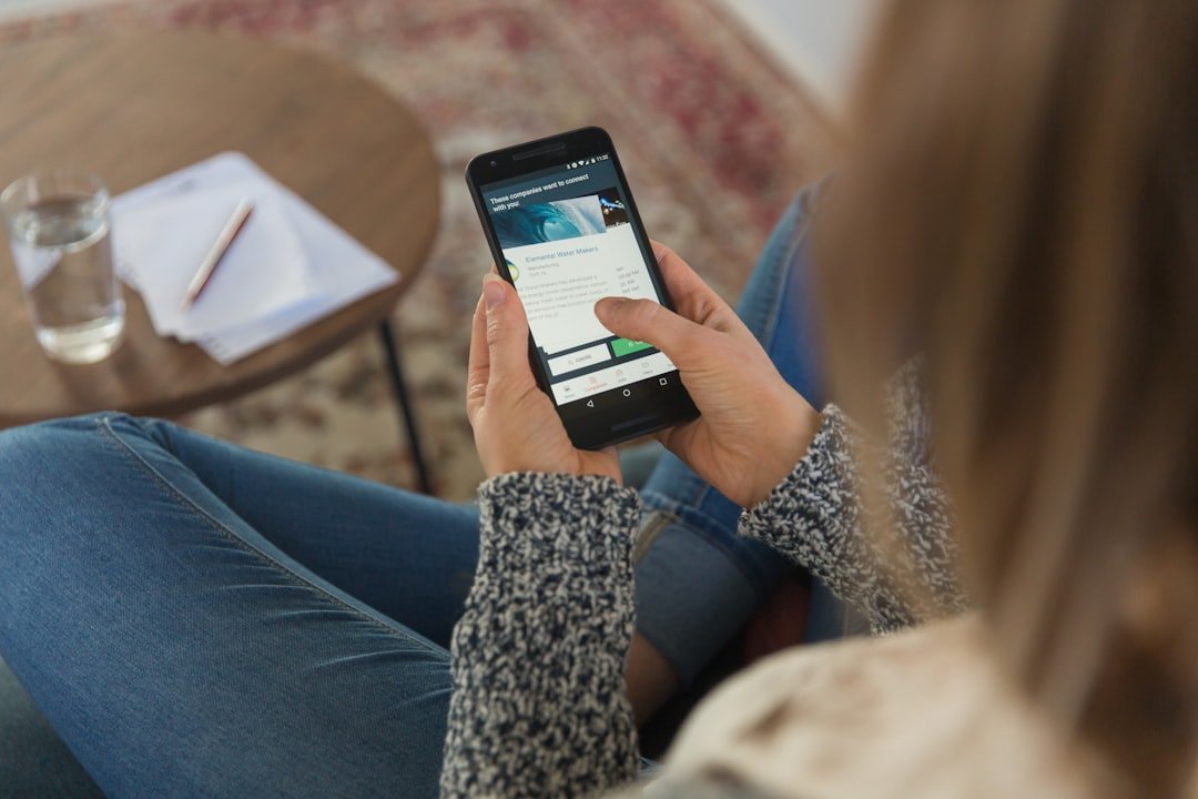 Person holding a smartphone with an AI assistant app open, illustrating the mobile AI app race between Meta and OpenAI