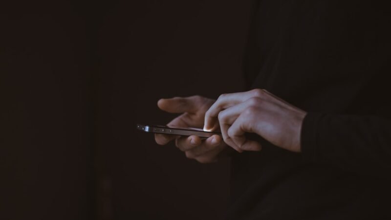 A person looking at a smartphone screen, representing social media platform advertising