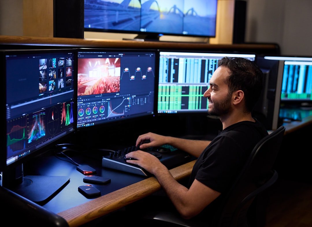 Programmer working across multiple computer monitors displaying code