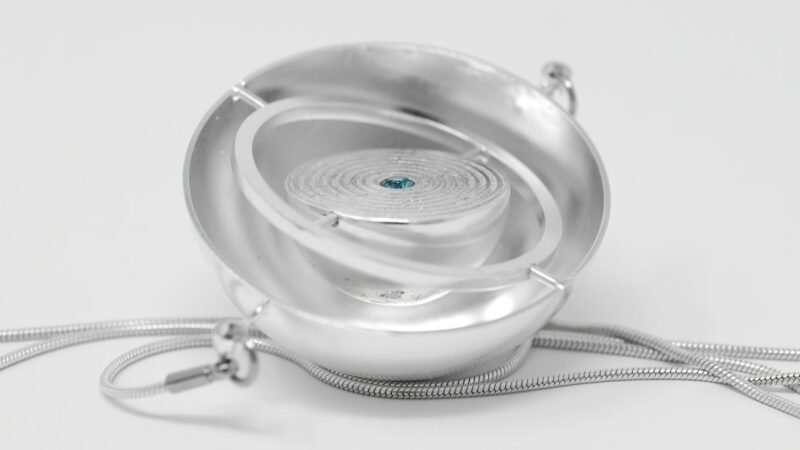 Silver pendant necklace with a small gemstone, representing wearable AI pendant devices