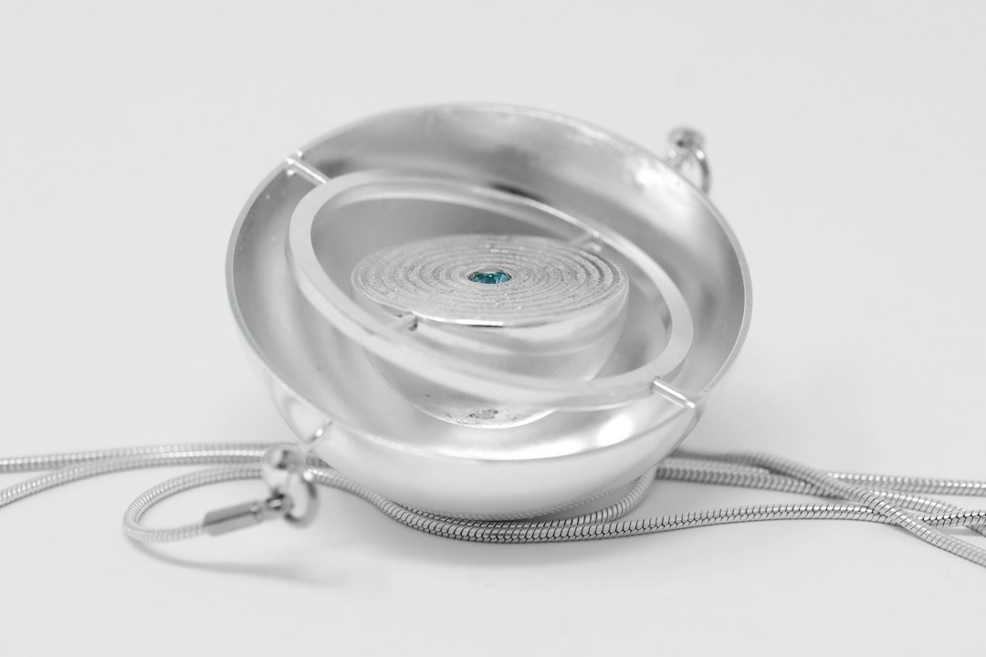 Silver pendant necklace with a small gemstone, representing wearable AI pendant devices