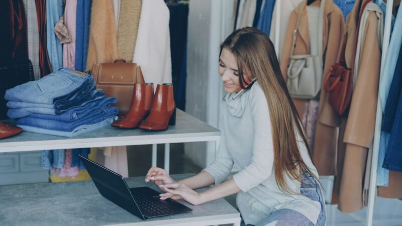 Small business owner using a laptop for free AI tools inside her shop