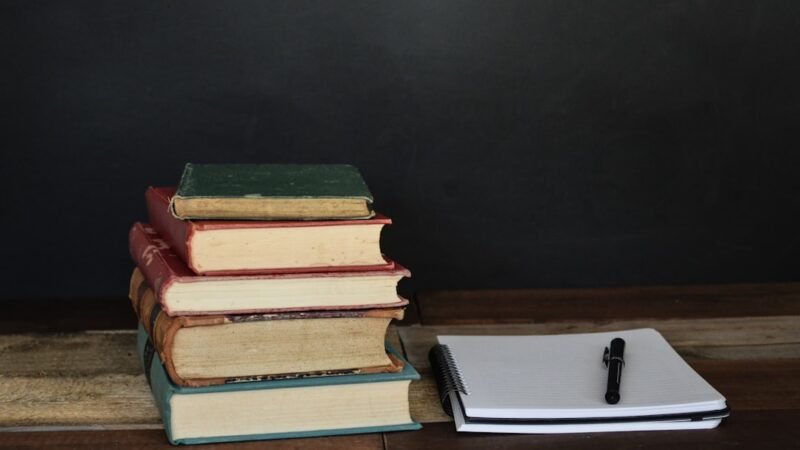 Stack of student papers on a teacher's desk, representing essay grading