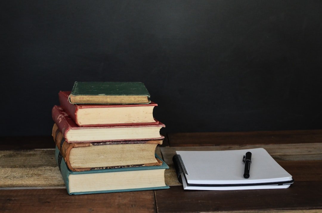 Stack of student papers on a teacher's desk, representing essay grading