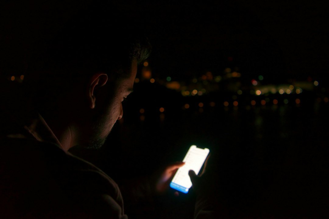 Teenager scrolling on a phone late at night, illustrating TikTok screen time limits