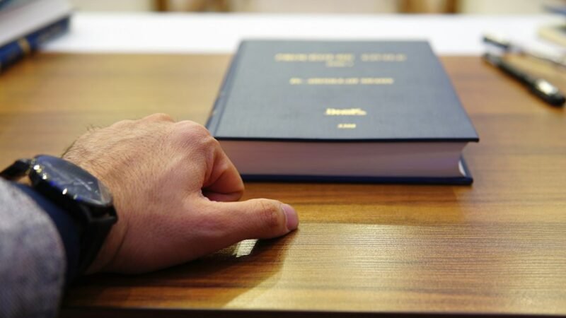 Lawyer reviewing documents with law books on the desk, representing legal AI software for law firms