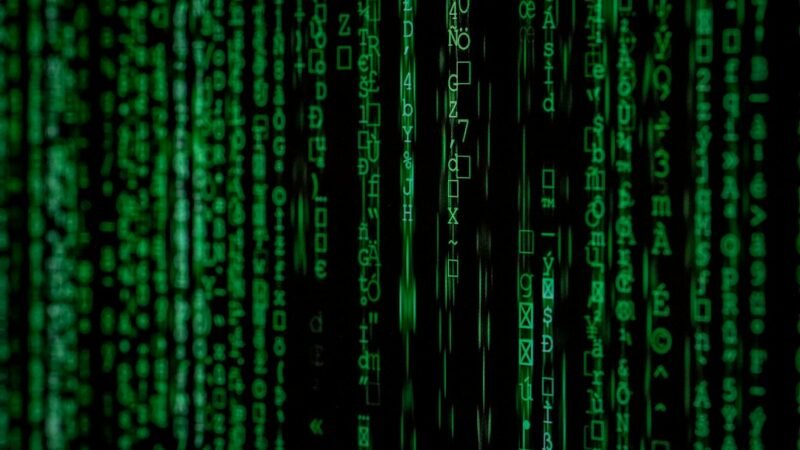 Abstract binary code on a dark screen representing offensive cybersecurity technology
