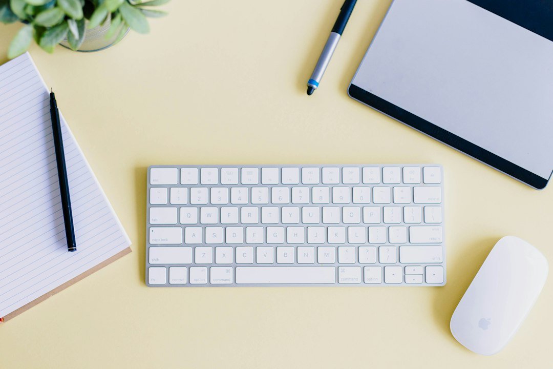 Flat lay of a desk with a laptop, tablet, and keyboard