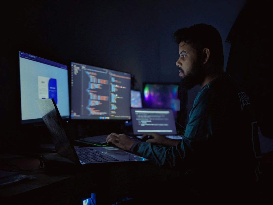 Developer working late with multiple code screens