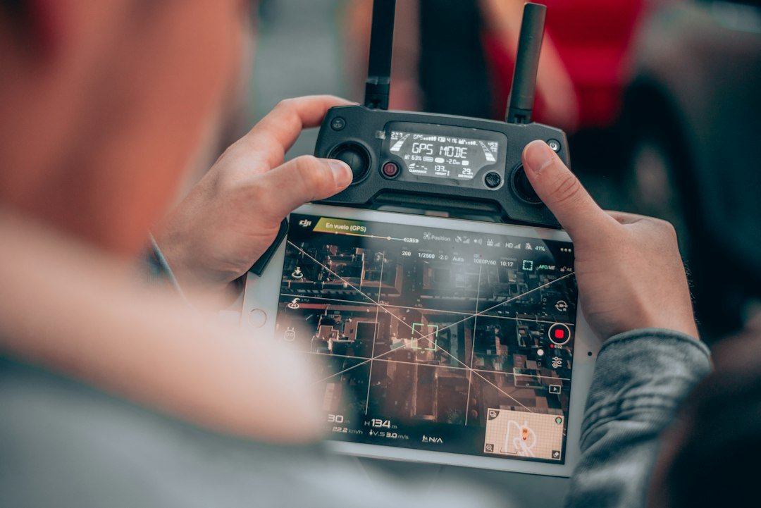 Person operating a drone camera controller representing autonomous systems development