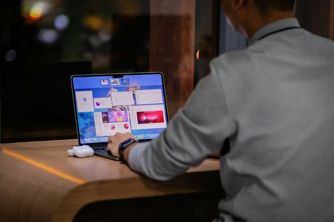 Entrepreneur working late on a laptop with a city skyline behind, illustrating the modern hustler meaning