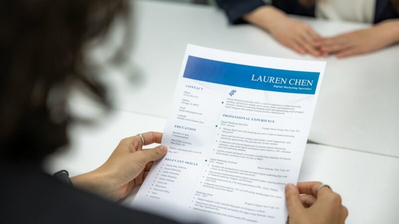 Job seeker reviewing a printed resume at a desk, representing free AI resume builders