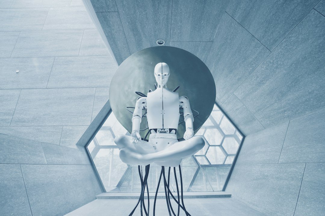 White humanoid robot seated in a research lab setting