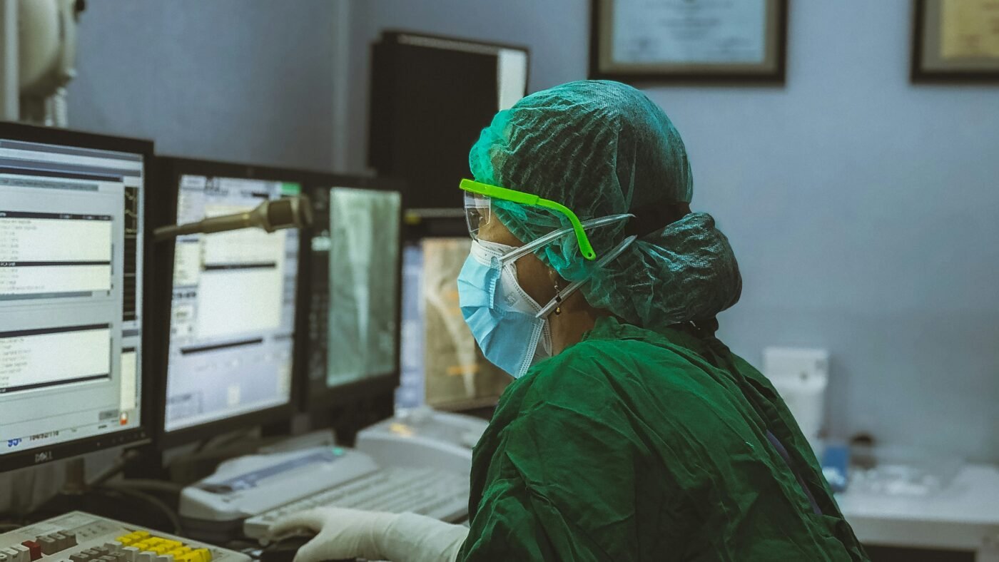 Lab technician at a monitoring station in a clinical lab control room