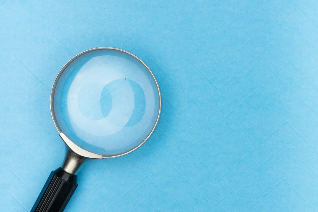 A magnifying glass resting on a white table, representing fact-checking content