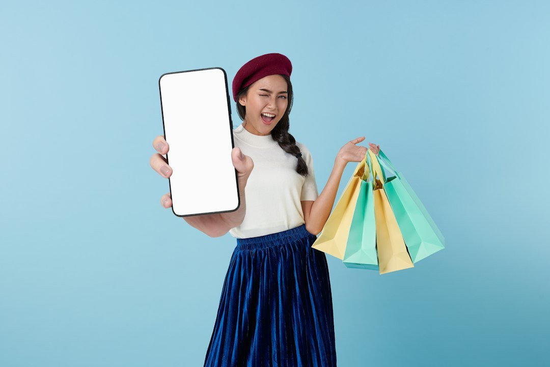 A woman holding a tablet computer and shopping bags, representing online clothes shopping