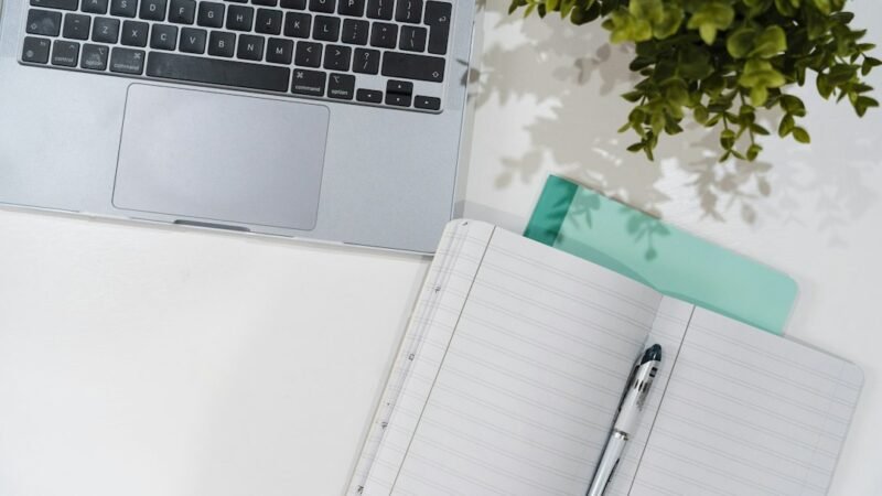 Laptop and journal on a desk, representing online side hustles you can start from home