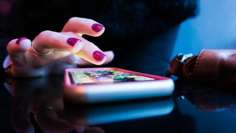 Person holding a smartphone showing an app screen
