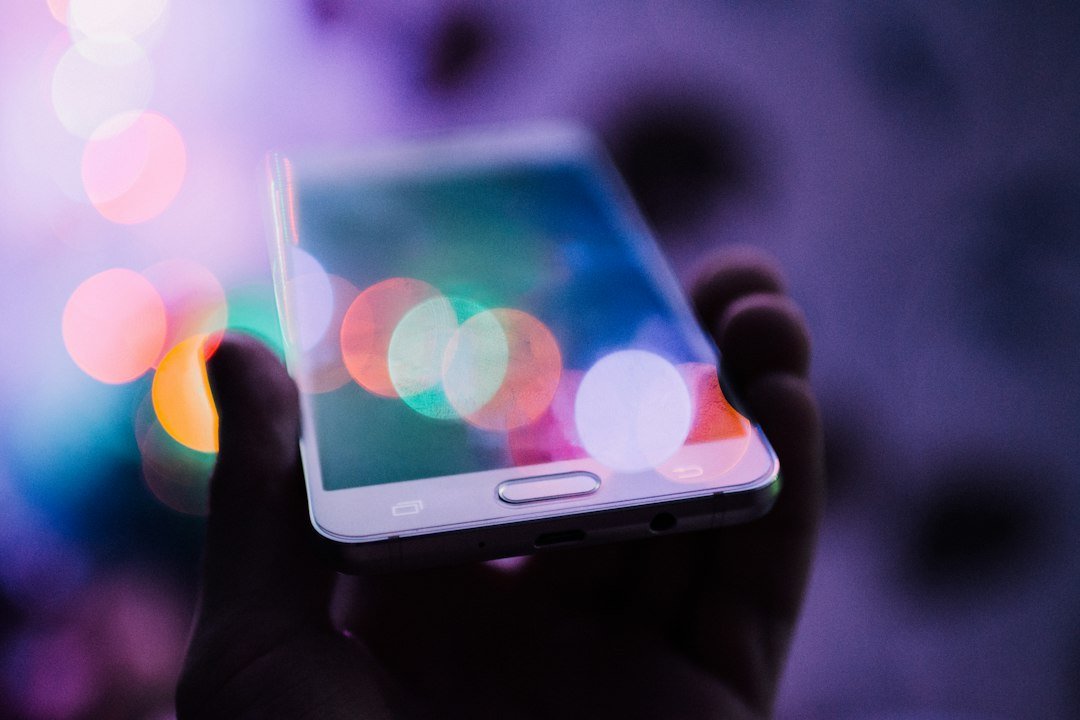 A person holding a smartphone, representing rising consumer device prices