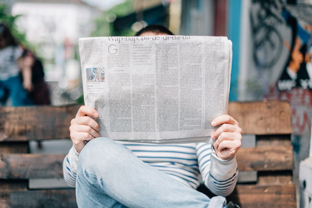 A person reading a printed newspaper